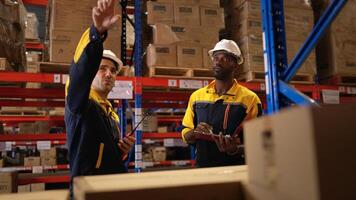 Two warehouse workers are reviewing the list of items based on the documentation,120 photo