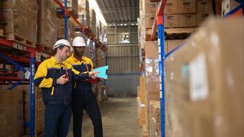 Two warehouse workers are reviewing the list of items based on the documentation,85 photo