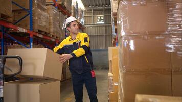 Two warehouse workers are lifting boxes of merchandise on a pallet jack to store on a shelf in a warehouse,75 photo