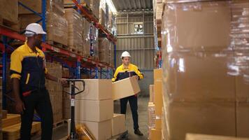 Two warehouse workers are lifting boxes of merchandise on a pallet jack to store on a shelf in a warehouse,69 photo