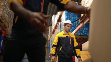 Two warehouse workers are lifting boxes of merchandise on a pallet jack to store on a shelf in a warehouse,61 photo