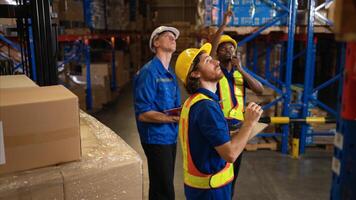 A bunch of warehouse workers are reviewing the list of items based on the documentation,36 photo