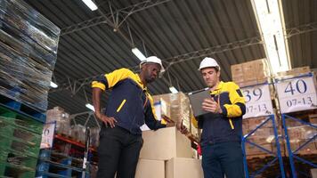 Two warehouse workers are reviewing the list of items based on the documentation,28 photo