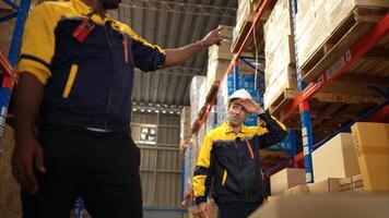 Two warehouse workers are lifting boxes of merchandise on a pallet jack to store on a shelf in a warehouse,25 photo