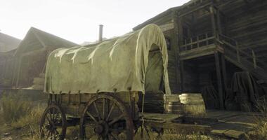 CGI Old wagon rests in front of an abandoned wooden building in a rustic setting video
