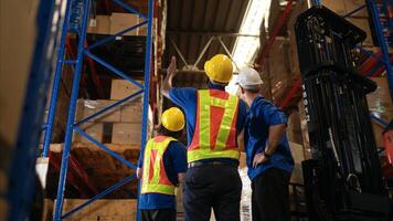 A bunch of warehouse workers are reviewing the list of items based on the documentation,11 photo