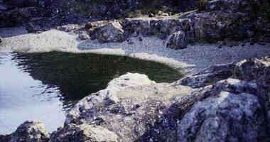CGI Serene rocky shoreline at a tranquil freshwater lake during sunset hours video