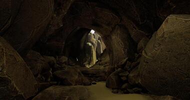 CGI Exploring a narrow cave passage with sunlight breaking through the rocks video