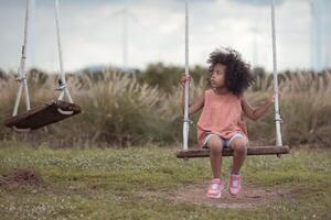 Little girl with swinging on a swing in picnic camping family day in wind turbine field,13 photo