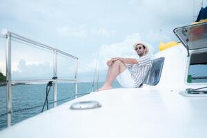 A young man is enjoying his seaside adventure aboard a yacht,125 photo