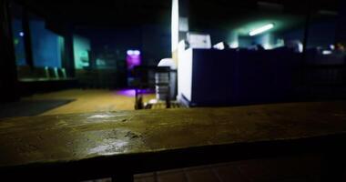 CGI Dimly lit indoor space with a wooden table and violet lighting at night video