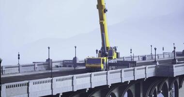 CGI Cranes are lifting equipment working on a bridge under a cloudy sky video