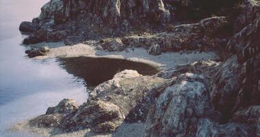 CGI Tranquil coastal rock formation at sunset reflecting on the calm water surface video