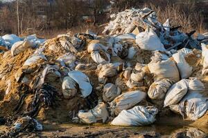 A large pile of construction debris at a landfill. Dump of various waste. Illegal dump. Negative impact on nature. Waste dump concept photo