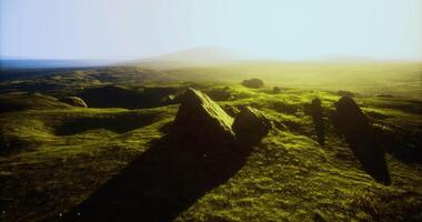 CGI Sunrise casts long shadows on grassy hills near the coastline video