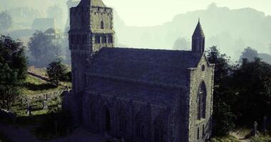 CGI Historic stone church nestled in a misty valley surrounded by trees video