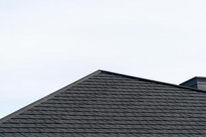 Dark asphalt tiles on the roof photo