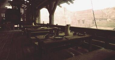 CGI Rustic dining area with wooden tables in an ancient structure during daytime video