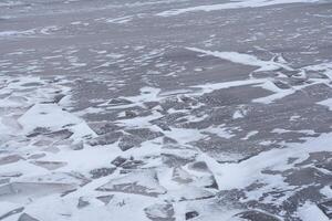 Cracks in the ice of the lake. Ice background texture. photo