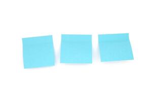 Three blue blank sticky notes on white background. Front view photo