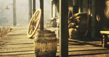 CGI Old wooden barrel and wagon wheel on porch of rustic building in sunlight video