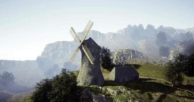 CGI Historic windmill stands on a hilltop surrounded by mountains and trees video