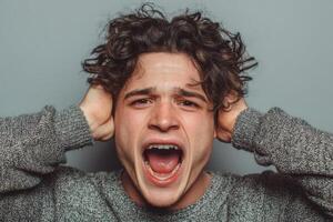 A man with his hands on his head and his mouth open photo