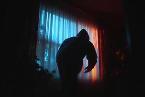 A person in a hoodie standing in front of a window photo