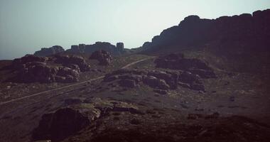 CGI Rocky landscape with winding path under hazy sunlight in the afternoon video