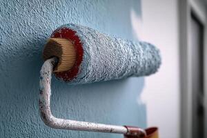 A paint roller and paint roller are on a wall photo