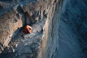 A tent is set up on a cliff side photo