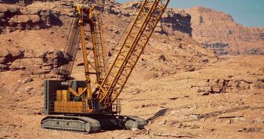 CGI Heavy machinery operates in rugged desert terrain during bright daylight video