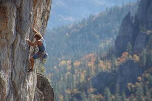 A man is climbing on a rock face photo