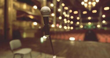 CGI Microphone in focus on stage with blurred audience in background video