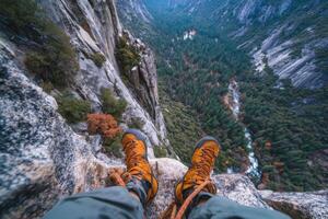 A person wearing hiking boots standing on the edge of a cliff photo