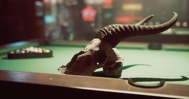 CGI Decorative skull on a pool table in a dimly lit bar setting at night video