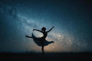 A woman in a dress is dancing in the night sky photo