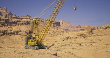 CGI Heavy machinery operates in a desert landscape during clear weather video