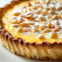 A close-up of a sweet and delicate torta della nonna dessert, a traditional Italian dessert, consisting of a shortcrust pastry shell filled with a creamy custard, infused with lemon zest, and topped with a sprinkle of pine nuts and powdered sugar, baked u photo