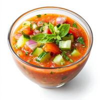 A vibrant summer gazpacho, a cold tomato-based soup blended with cucumbers, bell peppers, and onions, served in a glass bowl with a drizzle of olive oil. A refreshing and healthy dish. Isolated on clean white background photo