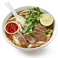 A steaming bowl of Vietnamese pho with thinly sliced beef, rice noodles, fresh herbs, and bean sprouts in a rich, aromatic broth. Served with a side of lime and chili sauce. Isolated on clean white background photo