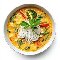 A Thai coconut curry, transformed with the addition of Japanese dashi broth and a touch of wasabi, served with rice noodles instead of white rice, an unusual and sophisticated fusion of Asian soup styles, isolated on a clean white background. photo