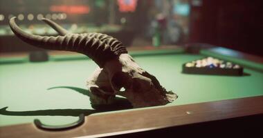CGI Skull with horns placed on a pool table in a dimly lit barroom video