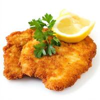 A crispy golden schnitzel with a side of lemon wedges and fresh parsley garnish. The breaded cutlet is fried to perfection, offering a crunchy exterior and tender inside. Isolated on clean white background photo