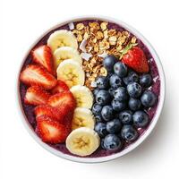 A vibrant acai bowl topped with fresh strawberries, blueberries, sliced bananas, granola, coconut flakes, and a drizzle of honey. A colorful and nutritious breakfast. Isolated on clean white background photo