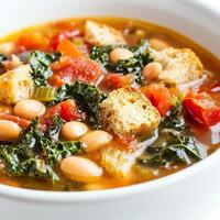 A close-up of a warm and comforting ribollita soup, a hearty Tuscan bread and vegetable soup, with beans, kale, tomatoes, and crusty bread, simmered until thick and flavorful, garnished with a drizzle of olive oil, isolated on clean white background. photo