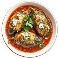 A plate of authentic Mexican chiles rellenos, featuring large poblano peppers stuffed with gooey melted cheese, dipped in a fluffy egg batter, and fried to golden perfection. Served with a rich tomato sauce and garnished with fresh cilantro and crumbled q photo