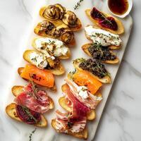 A vibrant platter of assorted crostini with elegant toppings, featuring grilled bread topped with smoked salmon and cream cheese, roasted beet and goat cheese, prosciutto and fig jam, and mushroom and truffle pate, arranged artfully on a marble board, per photo