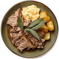 A plate of braised pork shoulder with milk and sage, featuring tender pork shoulder braised slowly in milk with fresh sage leaves, garlic, and other aromatics, resulting in a rich and flavorful meat dish, served sliced and accompanied by creamy polenta or photo