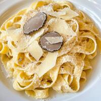 A plate of tagliatelle al tartufo bianco, featuring long, flat egg noodles, tossed in a rich and creamy sauce, made with butter, parmesan cheese, and shaved white truffles, resulting in a luxurious and highly prized pasta dish, showcasing the delicate aro photo